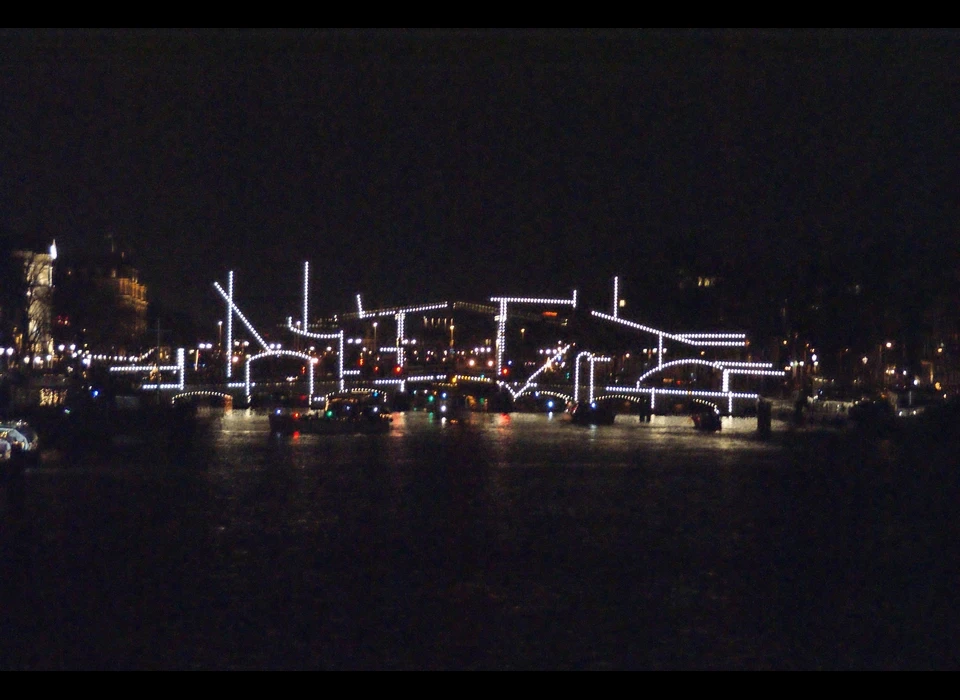 De Magere Brug telt zo’n 1800 lichtbollen die de 
					  contouren van de brug verlichten in de nacht. Krijn de Koning, wiens kunstenaarschap begon met tekenen, onderzocht of je met deze 
					  bestaande lichtlijnen een nieuwe tekening kan maken. 2019