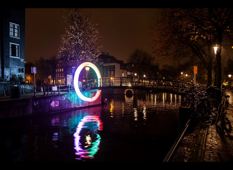 Rob van Houten ontwierp speciaal voor de Melkmeisjesbrug ‘Circle of Life’, een ring van licht rond de brug die de kunstenaar altijd 
					  weer doet voelen alsof hij een stukje boven de stad zweeft. ‘Circle of Life’ is een Möbiusring, het symbool voor oneindigheid. ‘Circle of Life’ gaat hierover: het eindeloze stromen van het water en van mensen 
					  naar de stad. De ring begint melkwit, als een lege stad die moet worden gevuld met leven. Wanneer iemand eronderdoor loopt, golft het licht weerskanten op, om zich met nieuwe kleuren te vermengen. (Rob van 
					  Houten (NL) is architect, ingenieur en ontwerper. Hij studeerde Architectuur en Bouwtechnologie aan de TU Delft.) 2014