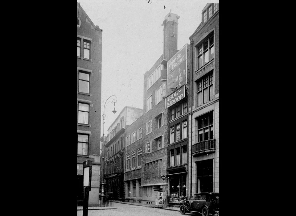 Inkijk in Warmoesstraat naar 173-183 de voorste panden maken nog geen deel uit van Krasnapolsky. (ca.1933)