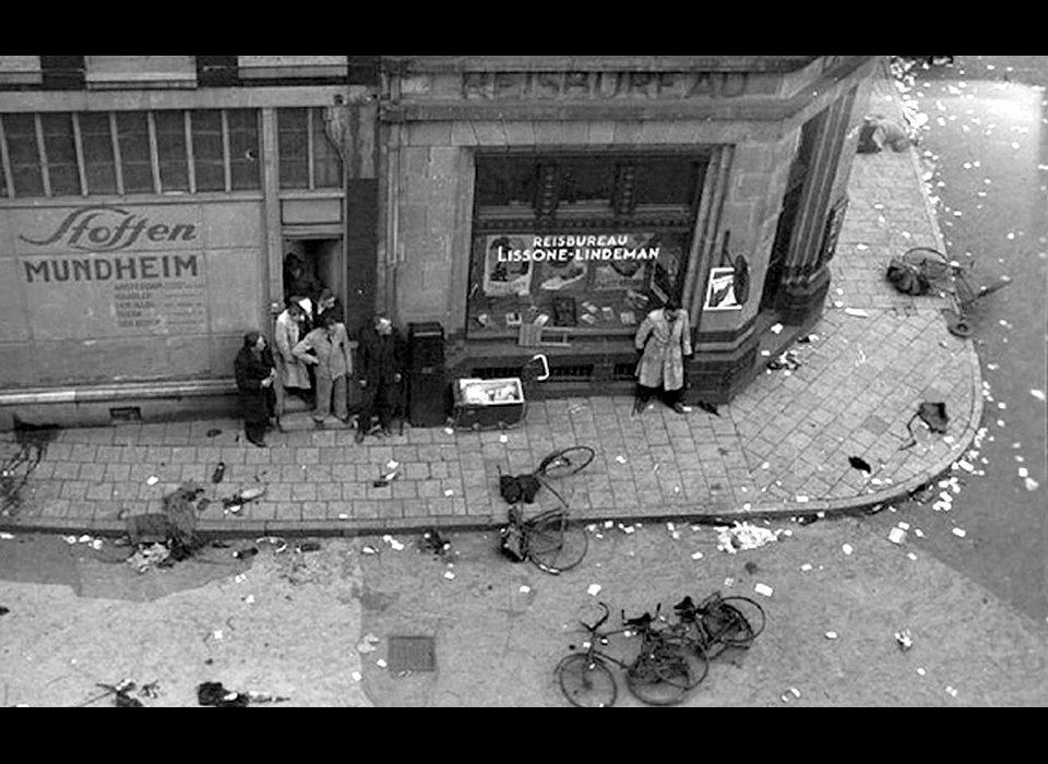 Dam 7 mei 1945 schuilen in de Eggertstraat voor de schietpartij door Duitse soldaten vanuit De Groote Club op de hoek van Paleisstraat en Kalverstraat