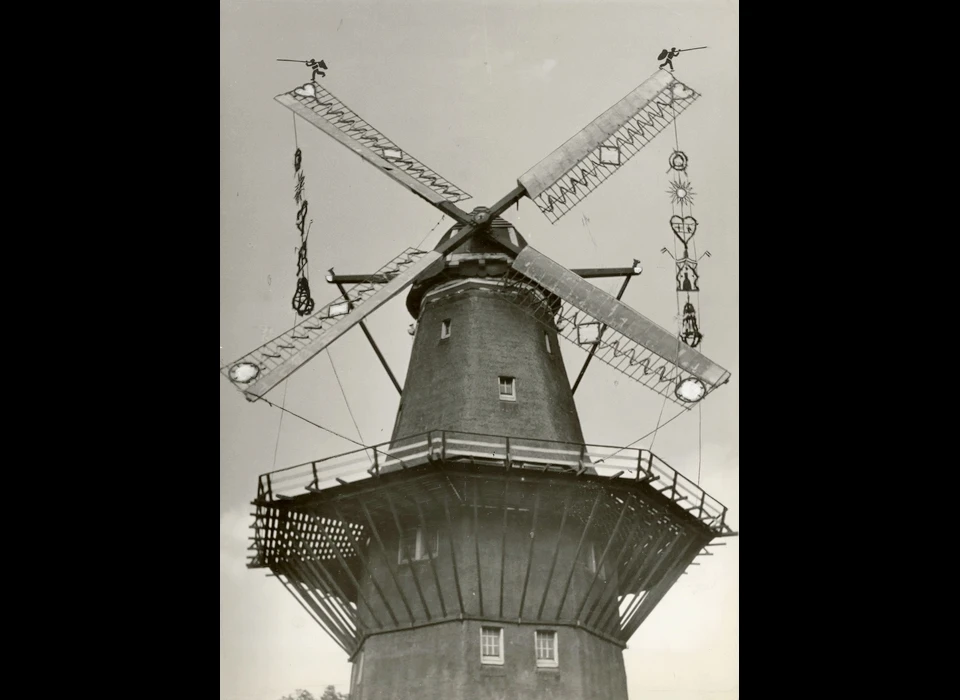 Funenkade 5 molen De Gooyer is 'mooi gezet', versierd naar oude (Zaanse) traditie met Mooimakersgoed tussen de overhek gezette wieken, in verband met het zilveren jubileum van de Vereniging De Hollandsche Molen en later dat jaar tijdens de inhuldigingsfeesten voor koningin Juliana (1948)
