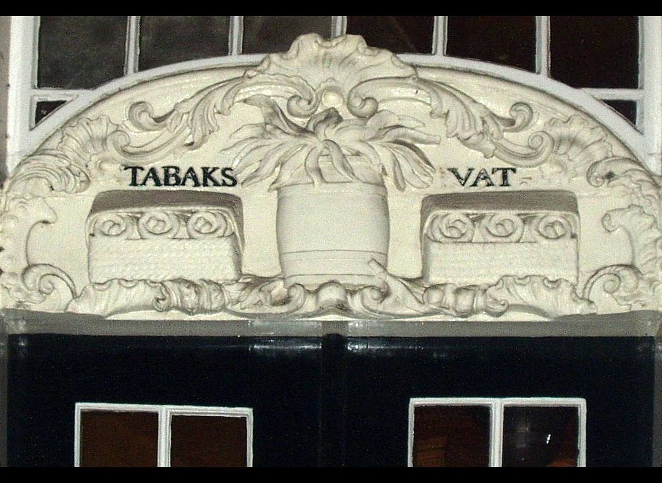 Geldersekade 8 deurbekroning Tabaksvat, vat en manden met tabaksbladen (1985)