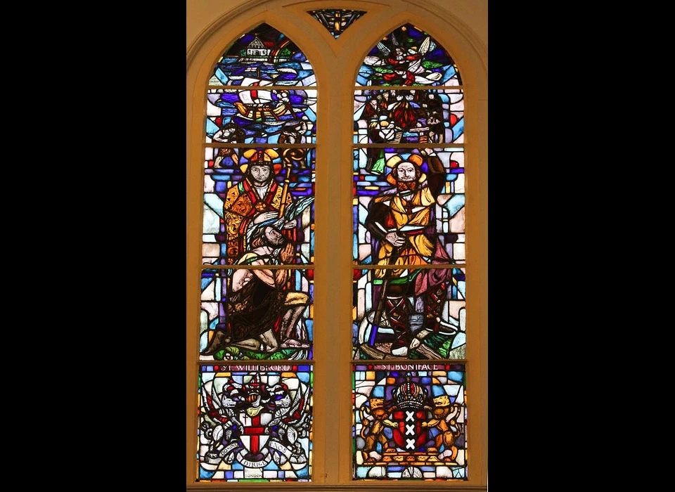Groenburgwal 42 glas-in-lood venster gewijd aan Bonifatius en Willibrord, twee Britse missionarissen, die in wat nu Nederland is, het evangelie verspreidden. Het raam is in 1931 geschonken door de stad Londen. (2018)
