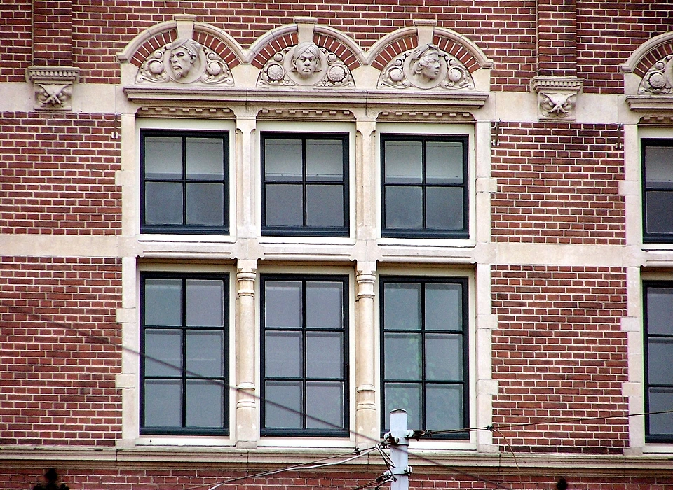 Mauritskade 63 Tropeninstituut de boogvullingen boven de ramen bevatten vele verschillende gezichten. (2014)