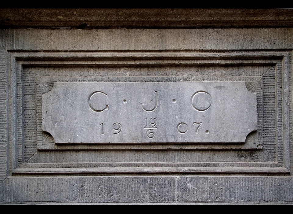 Nes 71-87 steen met tekst G.J.O. en datum 19-6-1907. Verwijzing naar architect of opdrachtgever en openingsdatum? (2021)