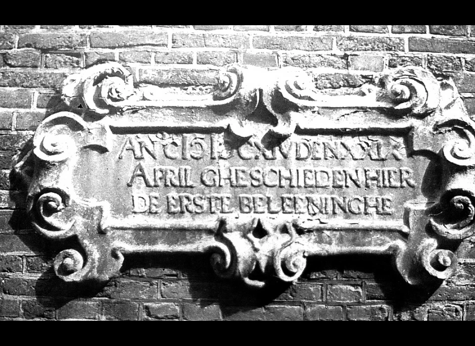 Nes 57 Anno 1614 de 29 april gheschieden hier de erste beleeninghe. Steen wellicht gehakt door Hendrick de Keyser. (1920)