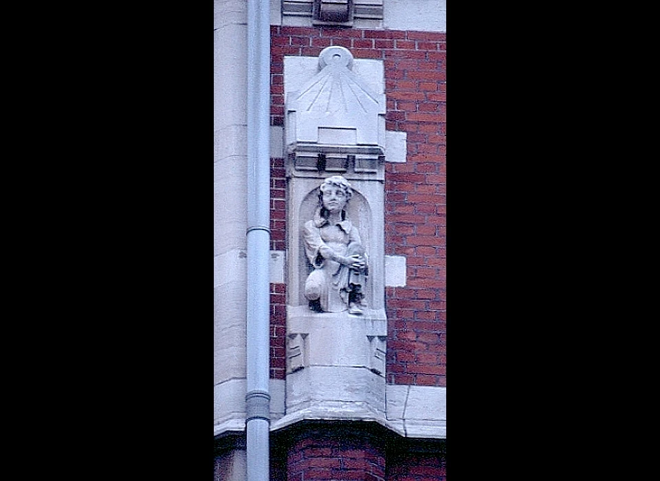 Nieuwe Doelenstraat 2-4 beeldhouwwerk knielend figuur in middeleeuwse kledij (1996)