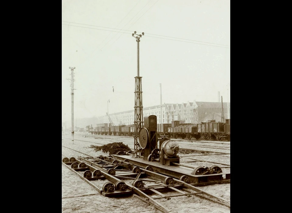 Plantage Doklaan elektrische traverseerinrichting op rangeerterrein. Met deze inrichting kon een wagon uit de rails gelicht en naar een naastliggend spoor verschoven. (1904)